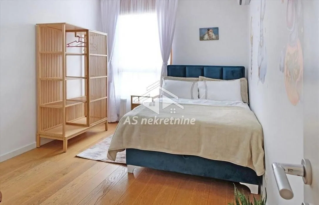 Furnished bedroom with a double bed and wooden wardrobe.