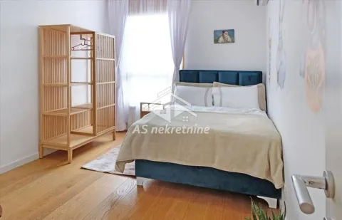 Furnished bedroom with a double bed and wooden wardrobe. - image 13