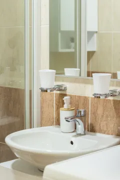 A view of the sink with a faucet and cup holders in the bathroom. - image 5