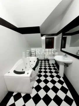 Kupatilo sa kadom, umivaonikom i crno-belim pločicama na podu. - image 17