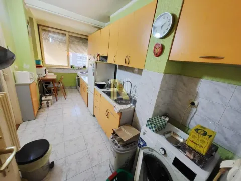 Manja kuhinja sa žutim elementima i trpezarijskim stolom pored prozora. - image 12