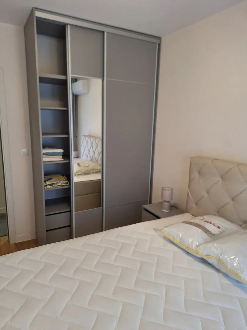 Svijetla spavaća soba sa velikim garderoberom i bračnim krevetom.