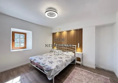 Bright bedroom with a double bed, wooden wall panel, and a window. - image 7