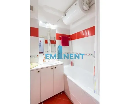 Bathroom equipped with a washbasin cabinet, bathtub, and water heater. - image 5