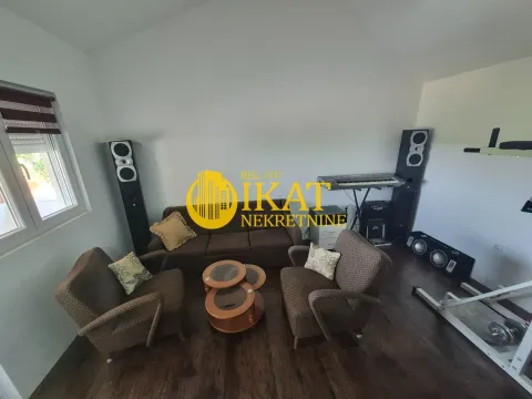 Nameštena dnevna soba sa garniturom za sedenje i audio opremom. - image 5