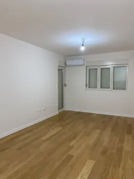 Empty room with white walls, wooden floor, and an air conditioner. - image 2