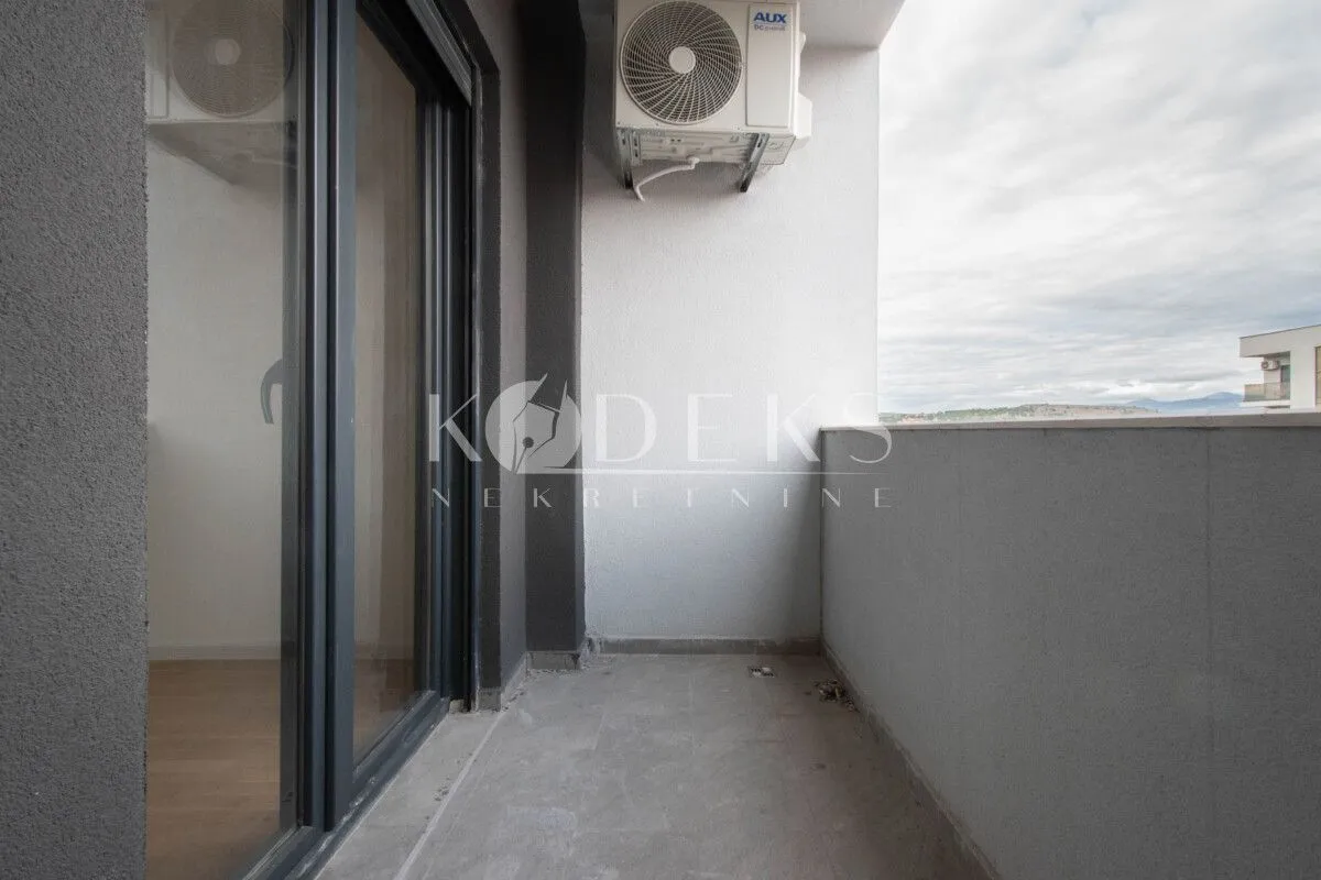 Unfurnished balcony with an outdoor air conditioning unit and sliding balcony doors.