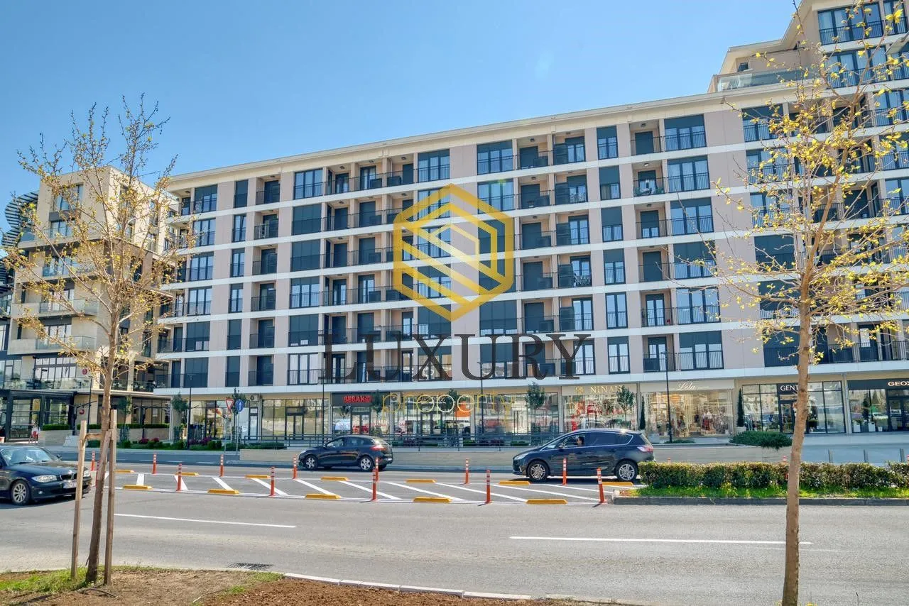 Spoljašnji izgled moderne stambene zgrade sa poslovnim prostorom u prizemlju.