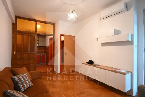 Living room with sofa, parquet flooring, and a view of the kitchen. - image 4