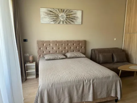 Furnished bedroom with a double bed and a sofa. - image 10