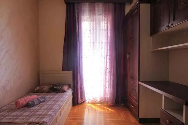 Dječja soba sa krevetom, radnim stolom i garderobnim ormarom.