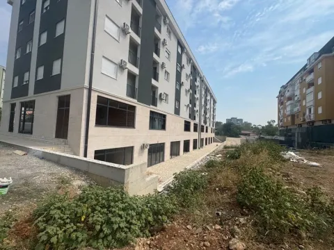 Pogled na spoljašnjost moderne stambene zgrade sa uređenim dvorištem. - image 2