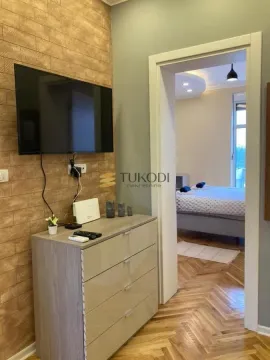 View from the living room towards the bedroom with a bed and parquet flooring. - image 7
