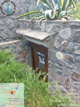 Pogled na kameni ulaz sa drvenim vratima i zelenilom. - image 3