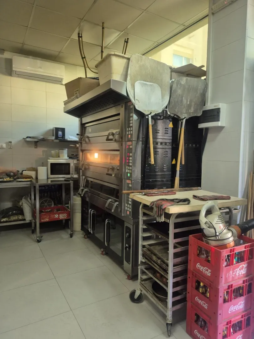 Commercial kitchen with a large oven and baking equipment.