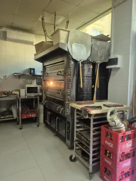 Commercial kitchen with a large oven and baking equipment. - image 14