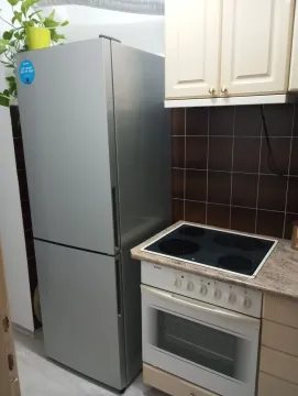 Small kitchen with a refrigerator, stove, and upper cabinets. - image 10