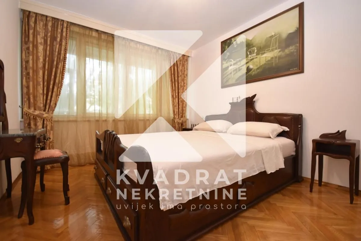 Bedroom with a double bed, wooden furniture, and a window with curtains.
