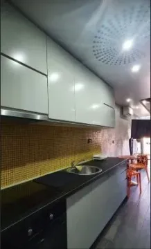 Moderna kuhinja sa bijelim elementima i tamnom radnom površinom. - image 3