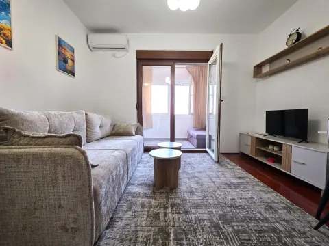 Dnevna soba sa garniturom, TV komodom i izlazom na terasu. - image 2