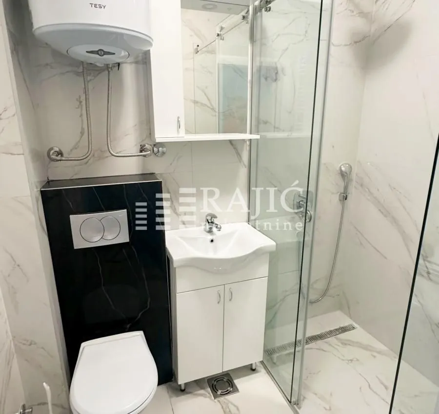 Modern bathroom with a walk-in shower, washbasin, and built-in sanitaryware.