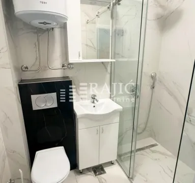 Modern bathroom with a walk-in shower, washbasin, and built-in sanitaryware. - image 9