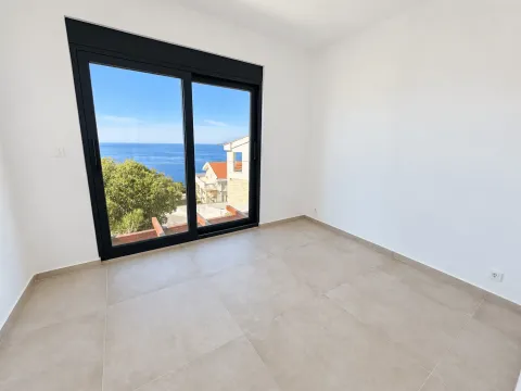 Empty room with large glass balcony doors and a sea view. - image 11