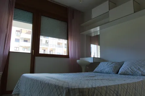 Furnished bedroom with a double bed and balcony access. - image 8