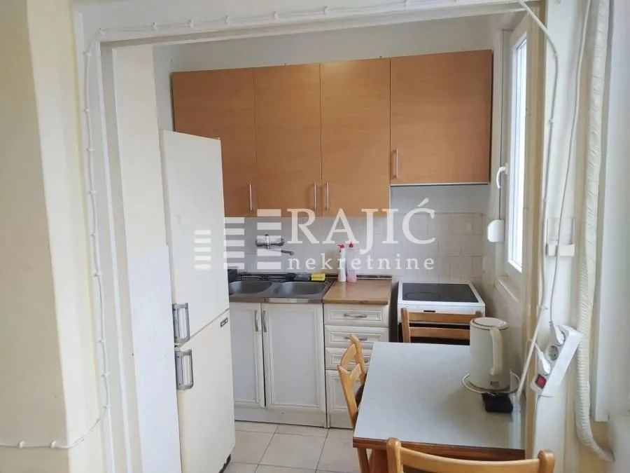 Small kitchen with wooden cabinets and a dining table.