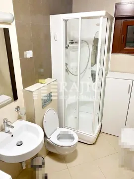 Smaller bathroom with a shower cabin, washbasin, and toilet. - image 5