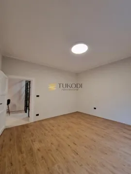 Empty room with laminate flooring and white walls. - image 15