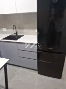 Pogled na deo moderne kuhinje sa sudoperom i frižiderom. - image 3