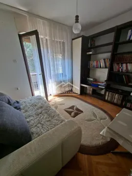 Dnevni boravak sa garniturom, velikom bibliotekom i izlazom na terasu. - image 14