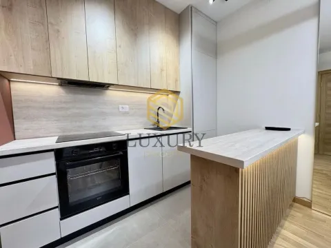 Modern kitchen with white and wood elements and a bar counter. - image 4