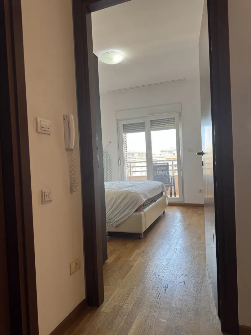 Pogled kroz vrata na svijetlu spavaću sobu sa izlazom na terasu.