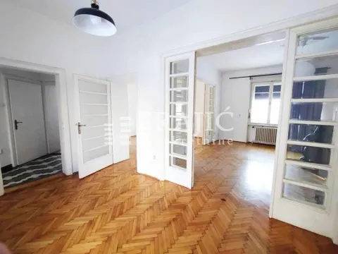 Empty room with wooden parquet flooring and double doors. - image 2