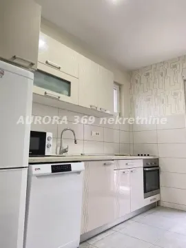 Kuhinja opremljena belim elementima, frižiderom i ugradnom rernom. - image 6