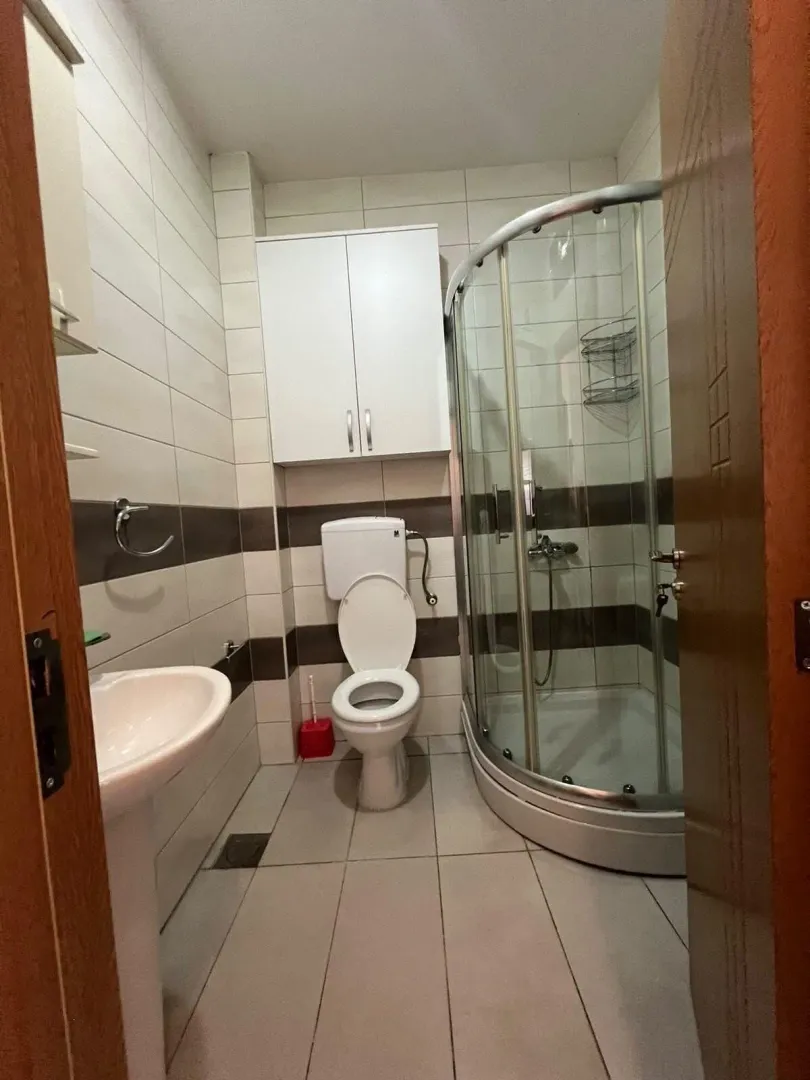 Small bathroom with a shower cabin, sink, and toilet.