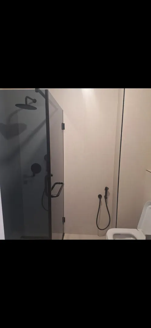 Moderne kupatilo sa tuš kabinom i toaletom.