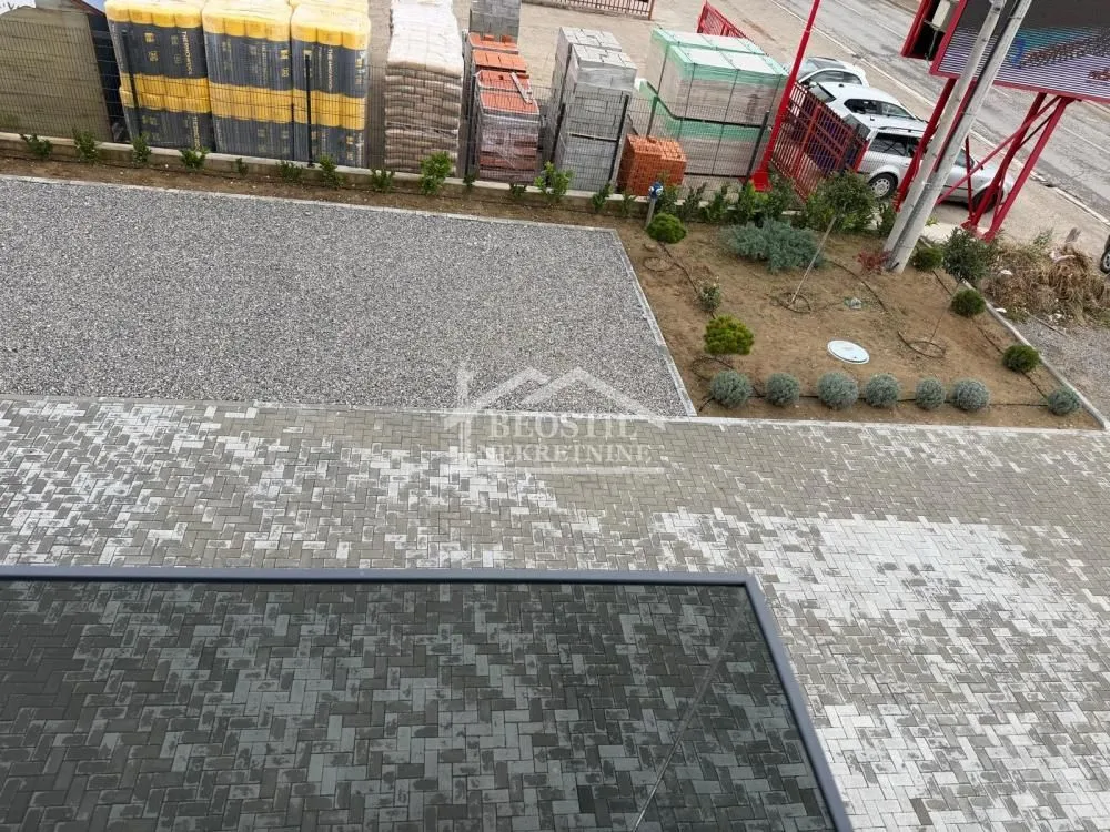 High-angle view of the paved courtyard and parking space in front of the building.