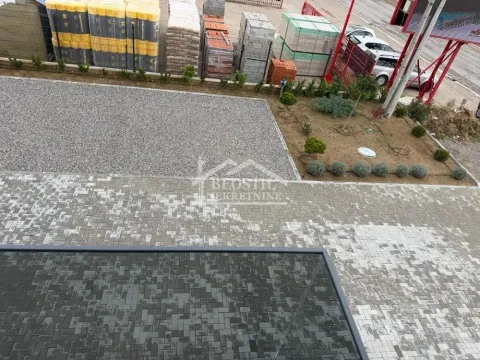 High-angle view of the paved courtyard and parking space in front of the building. - image 9