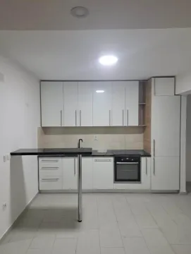 Moderna bijela kuhinja sa ugrađenom rernom i šankom. - image 3