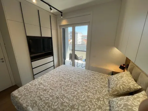 Modern bedroom with a double bed, built-in wardrobe, television, and access to the terrace. - image 14
