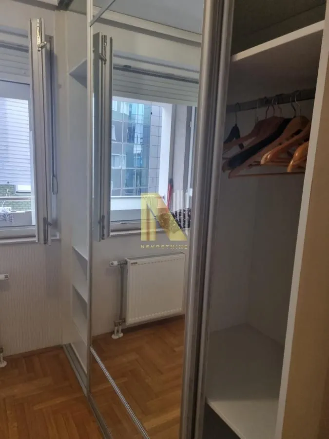 Spavaća soba sa ugradnim ormarom i ogledalom.