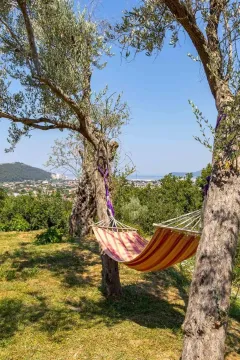 Dvorište sa ležaljkom između stabala i pogledom na prirodu. - image 13