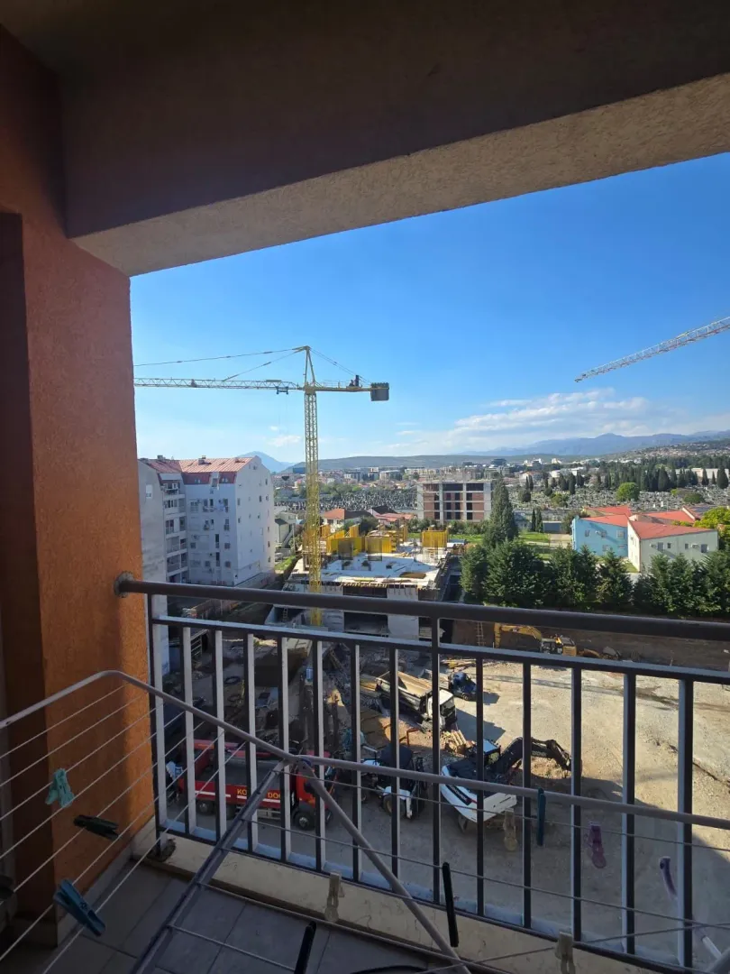 Pogled sa balkona na gradilište i okolne zgrade.