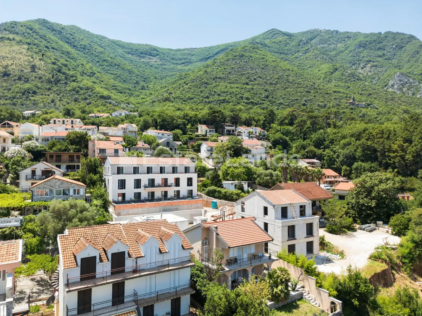 Pogled iz vazduha na naselje i okolne planine.