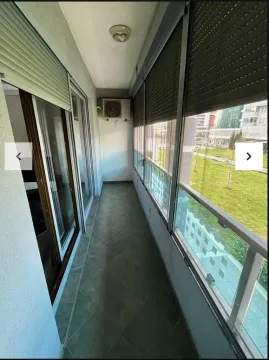 Enclosed balcony with floor tiles and a view of greenery. - image 7
