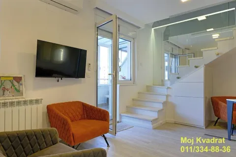 Dnevna soba sa foteljama, televizorom na zidu i stepeništem koje vodi na sprat. - image 2