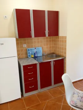 Small kitchen with red cabinets and a white refrigerator. - image 6
